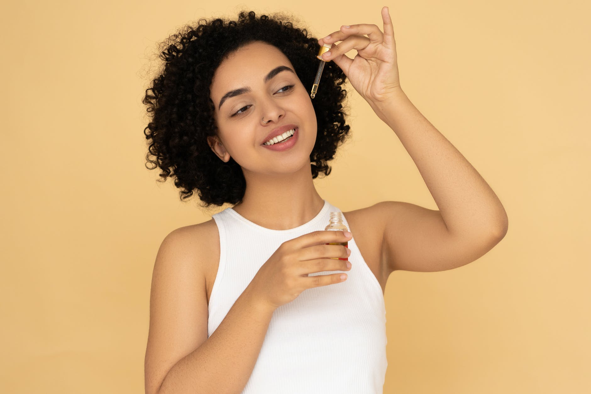 woman in white tank top holding a bottle