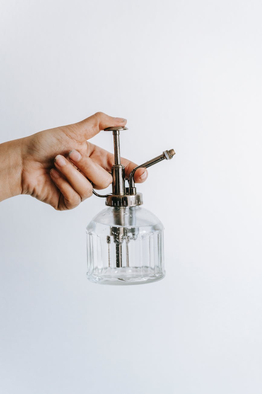 crop gardener with empty spray bottle on white background