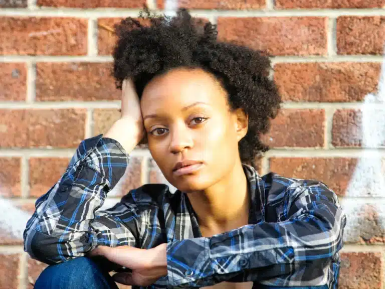 black woman with medium natural hair with hand holding the head as if worried about something