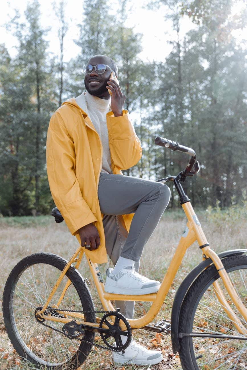 man in yellow jacket riding on a yellow bicycle