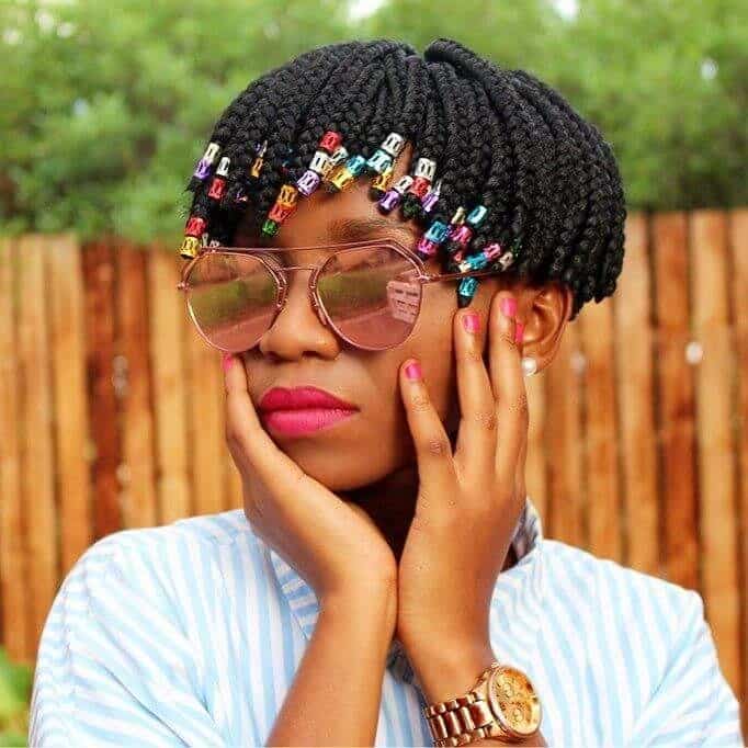 Black woman wearing short box braids and shade sunglasses