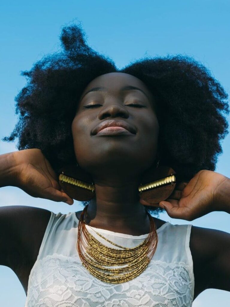 dark-skin-woman-with-beautiful-natural-hair-wearing-white-sleeveless-lace-shirt.
